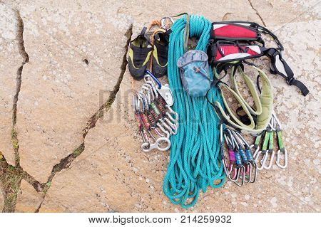 Climbing equipment - bag for magnesia rope and carbines view from the top close-up. A coiled climbing rope lying on the ground as a background. Concept of outdoor sport