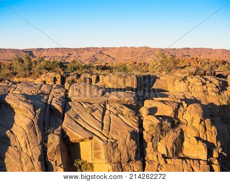 Golden hour at the granite cliffs near the waterfall at Augrabies Falls National Park in the Northern Cape of South Africa.