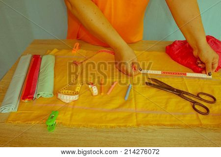closeup of woman hands sewing yellow cloth outdoors. Woman's Hand Sewing Quilt