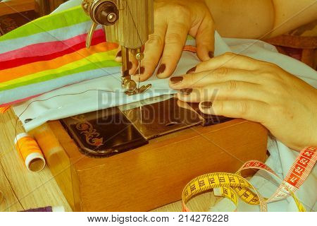 closeup of woman hands sewing yellow cloth outdoors. Woman's Hand Sewing Quilt