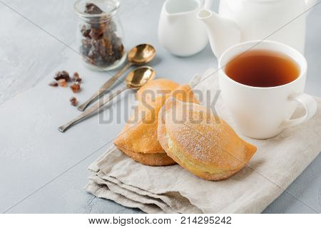 Pasties with cottage cheese and powdered sugar on a gray stone or concrete background. Traditional Russian pastry Sochnik. Selective focus. Top view.