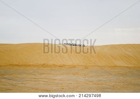 Group of off-roadster cars on sand hill. Car tour of the Sahara desert. Tunisia.