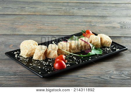 Horizontal shot of cheese balls with sezam served on a plate with cherry tomatoes and some greens tasty delicious appetizers restaurant gourmet menu delicacy food eating concept.