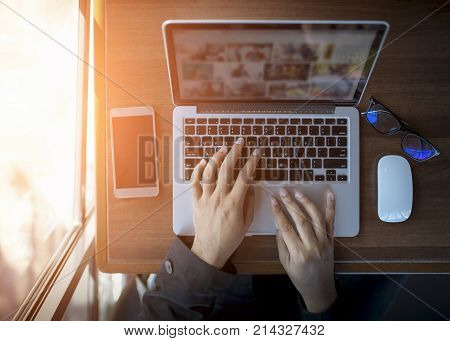 Businessman at work. Close-up top view of man working on laptop while sitting at the wooden desk