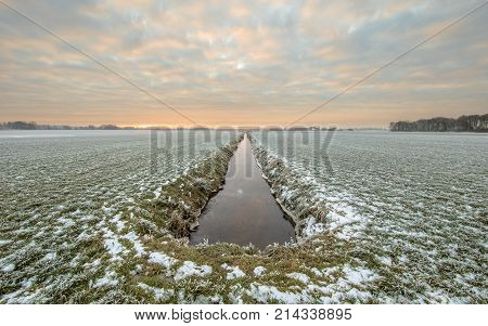 Frozen Grassland With Straight River Canal