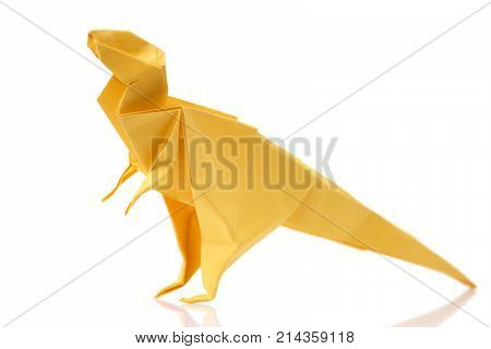 Yellow tyrannosaurus on white background. Kid's origami project, dinosaur theme. Creative work concept.