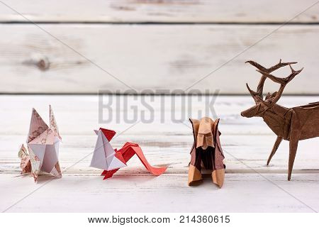 Origami animal models. Fox, rooster, lion and deer made of colored paper. Children's art works.