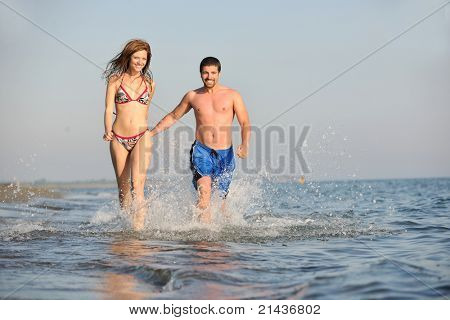 Szczęśliwa młoda para miłej zabawy i romantyczne chwile na plaży w sezonie letnim i reprezentujących happynes