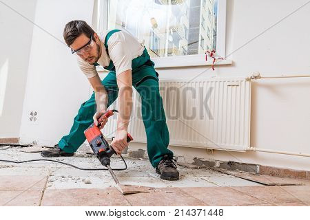 Demolition Of Old Tiles With Jackhammer. Renovation Of Old Floor