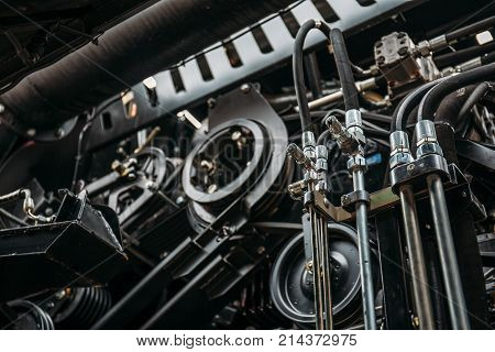 Harvester engine, gear chains, mechanisms transmission of new modern technology combine vehicle motor with metal, chrome, plastic parts, heavy agricultural industry equipment, selective focus