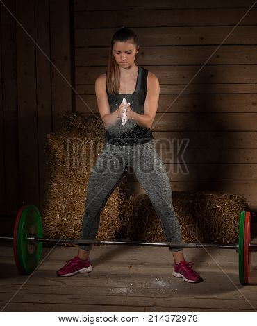 Active Young Fit Woman Claping Hands With Magnesium On Them Before Lifting Barbell Weights