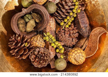 Christmas potpourri table decoration. Traditional xmas pinecone and berries centrepiece. Golden brown seasonal festive display.
