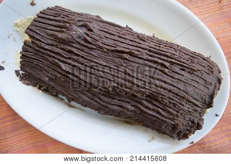 chocolate yule log cake with stuffing of cream and candied