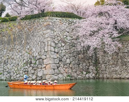 Himeji, Japan - April 10, 2017 : Tourist cruise boat on a canals around Himeji Castle. On the day of cherry blossoms in full bloom. Himeji-Jo Castle is famous travel spot in kansai area in Japan.