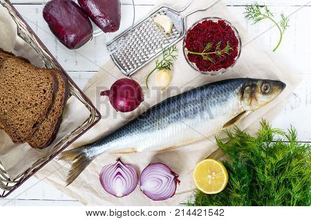 Whole salted herring with boiled beet red onion garlic lemon dill rye bread. Ingredients for sandwich salad.