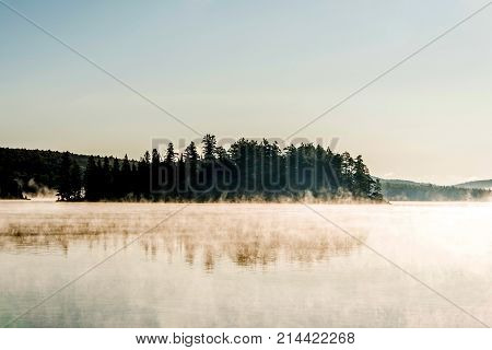 Lake of two rivers in algonquin national park ontario canada sunset sunrise with fog foggy mystical atmosphere background