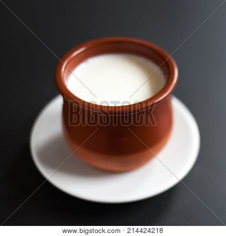 Sour cream or natural Cottage cheese curd in traditional ceramic bowl on dark background. Traditional Cuajada yogurt cream