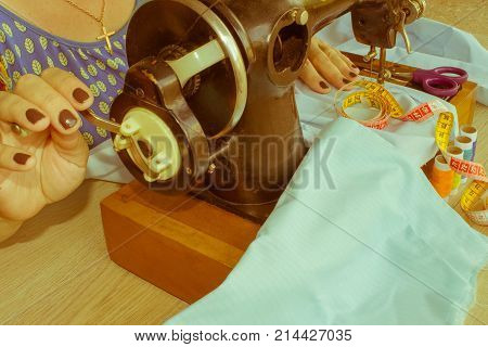 Woman hand on sewing machine.Dressmaker work on the sewing machine. Hobby sewing fabric as a small business concept. Female tailor threading leather material on sewing machine
