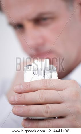 background image of serious businessman holding an open pack of cigarettes