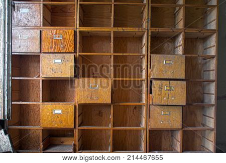 A forgotten empty document cabinet. Old damaged office cupboard case with open drawers.
