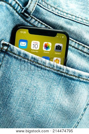 PARIS FRANCE - NOV 10 2017: New Apple iPhone X smartphone telephone mobile in pocket of fashion denim jeans pants trousers with home screen apps