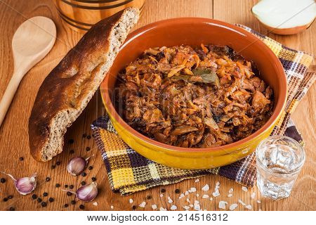 Traditional Polish bigos and fresh homemade bread closeup