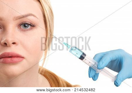 The hands of the cosmetologist are going to make an injection of an attractive woman. Isolated on white background.