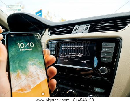 FRANKFURT GERMANY - NOV 4 2017: Man connecting his new iPhone X 10 to the navigation system of the car with CarPlay - message on GPS - new device detected