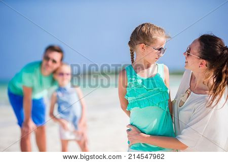 Happy beautiful family with kids together on tropical beach during summer vacation