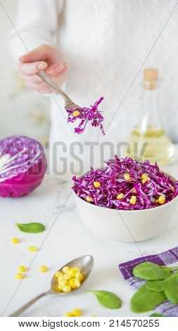 Salad Of Red Cabbage And Corn. Woman's Hand Holds Fork With Salad