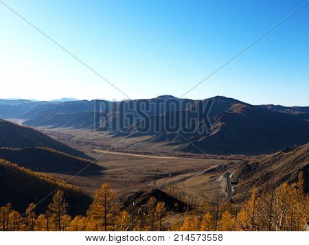 Fantastic panorama of a large mountain range. The winding mountain road. The autumn time of the year.