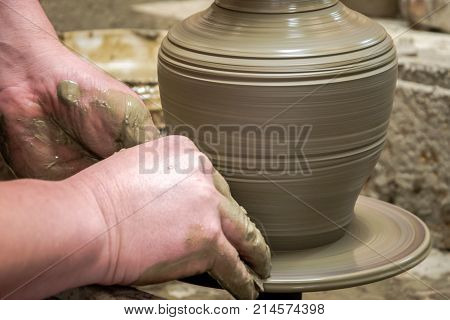 Man potter at work creating some traditional cups of white clay, Psychro, Lassithi, Crete, Greece.