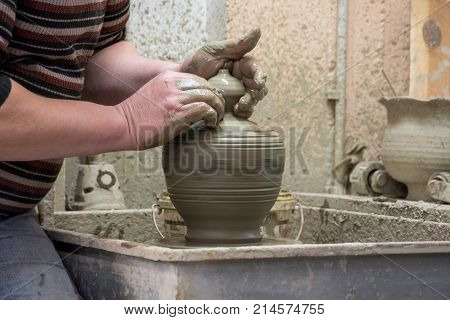 Man potter at work creating some traditional cups of white clay, Psychro, Lassithi, Crete, Greece.