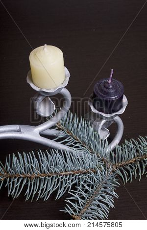 The Branches Of The Blue Spruce Lie On The Plane. Among Them, Candles Are White And Black On A Forge