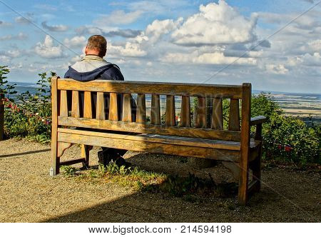 man sitting on a wooden bench watching the fabulous scenery