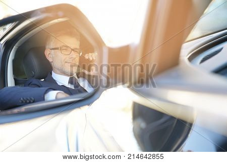 Taxi driver talking on phone while waiting for client