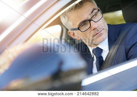 Portrait of businessman driving car for work