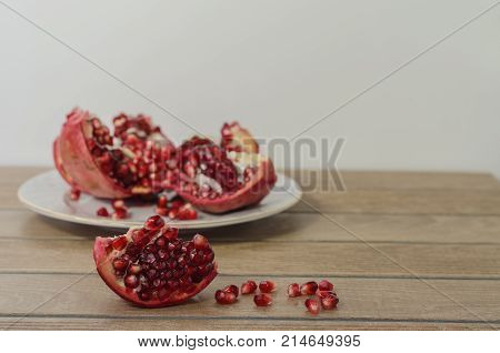 pomegranate on the backgraund pomegranate slice in front and fallen pomegranate