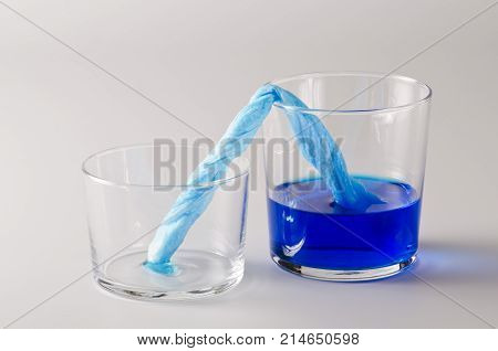Physics. Capillary action. Dyed water is moving up through paper towel. 