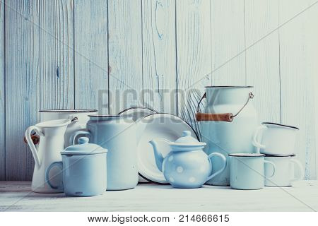 Enamelware on the kitchen table over blue wooden wall