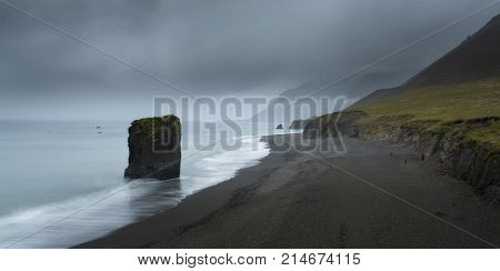 Typical Icelandic seascape with black basalt sand. Dramatic summer evening on the west coast of Iceland Europe. Artistic style post processed photo