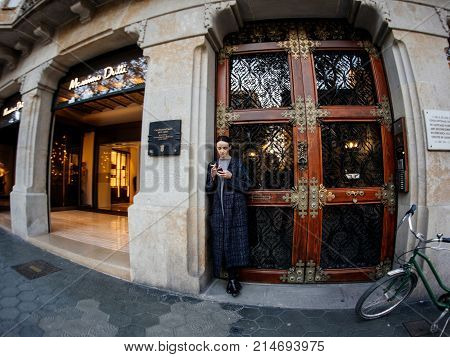 Young Stylish Woman Smoking And Using The Mobile Phone Smartphone Near The Entrance Of The Luxury Ma