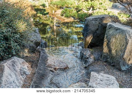 Water flows between rocks into a pond in Seatac Washington.