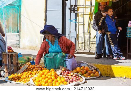 HUARAZ, PERU - JULY 27: Traditionally dressed peruvian people sell fruits and vegetables on the street market on July 27, 2017 in Huaraz, Peru.