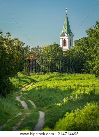 Path through grass and trees to church of Jedlesee Vienna Austria