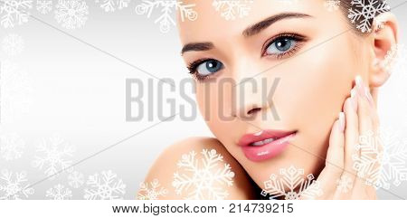 Closeup headshot portrait of a beautiful woman with beauty face and clean smooth soft skin , mild makeup. Grey steel background with snowflakes and a place for your information