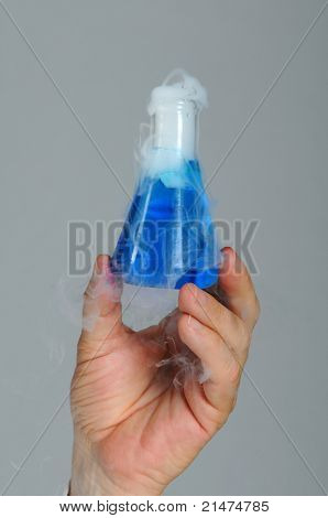 นักวิทยาศาสตร์มือถือขึ้นบีกเกอร์ของเหลวสีน้ำเงิน มีควัน billowing ออก Closeup ในแนวรวดเร็ว