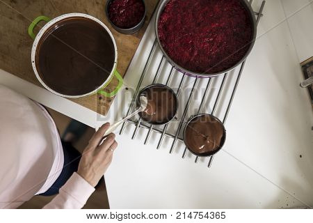 Top view of woman making a chocolate sauce or cake mix while baking in the kitchen.