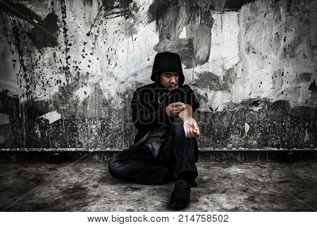 Drug abuse concept. Overdose asian male drug addict in action with drugs narcotic syringe in hand.