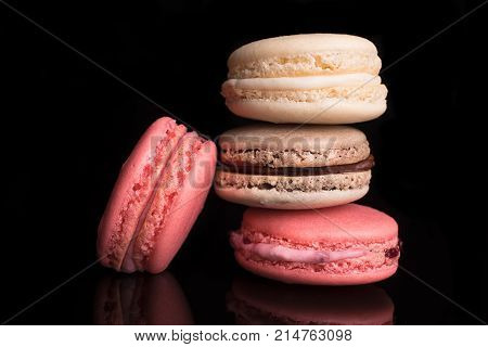 Sweet colorful french macarons macaroons on a black background chocolateraspberryvanila.